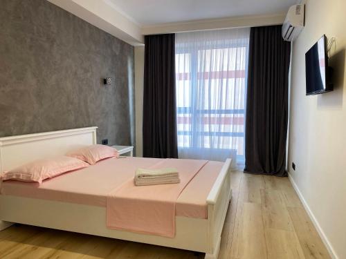 a bedroom with a bed with pink sheets and a window at New chisinau in Chişinău
