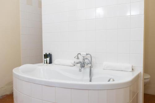 une baignoire blanche dans une salle de bain avec un lavabo dans l'établissement La Villa Jaume, à Argelès-sur-Mer