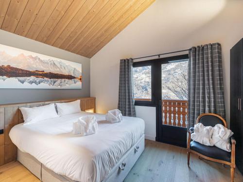 une chambre avec un lit avec des draps blancs et une fenêtre dans l'établissement Chalet familial moderne à Méribel Village, terrasse sud avec jacuzzi, proche pistes et commerces - FR-1-566-56, à Les Allues