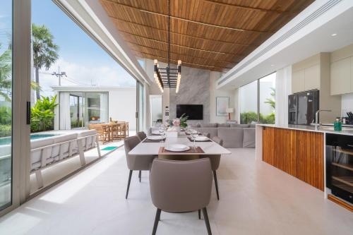 an open kitchen and living room with a table and chairs at Luxury villa near Bangtao beach in Phuket