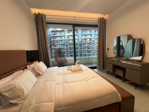 a bedroom with a bed and a desk and a window at Amazing Dubai Silicon Oasis Rental Apartments in Dubai