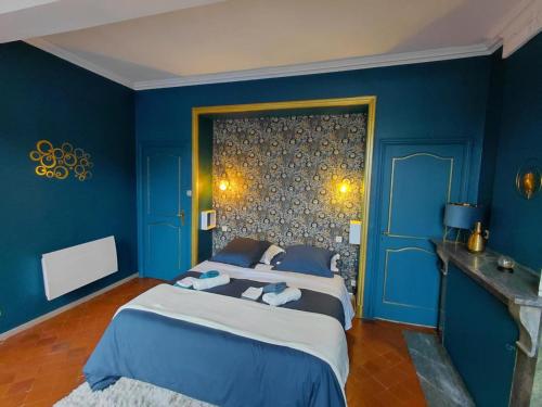 Un dormitorio con paredes azules y una cama grande. en La Résolue, en Millas