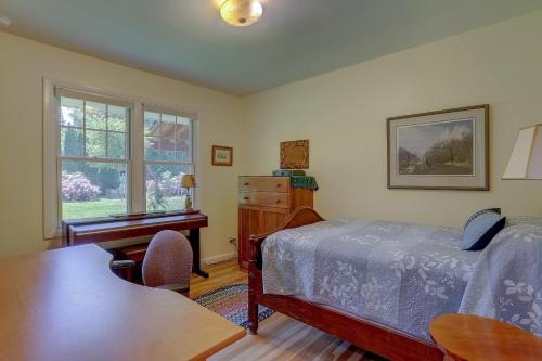a bedroom with a bed and a desk and a table at Living Color Cottage in Hood River