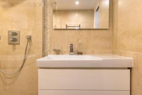 een badkamer met een witte wastafel en een spiegel bij Évasion et Confort Aubagne in Aubagne