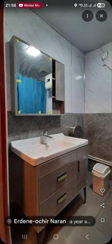 a bathroom with a sink and a mirror at Bee Happy Hostel & Gobi amazing tour in Dalandzadgad
