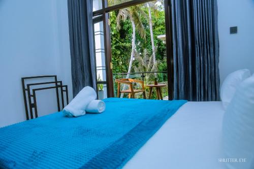 ein Schlafzimmer mit einem Bett und einem großen Fenster in der Unterkunft Zeyora Mirissa in Mirissa