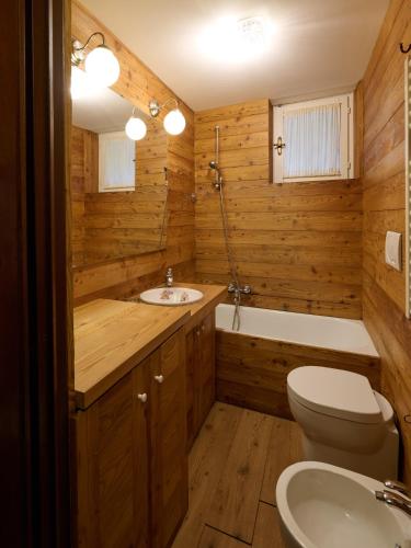 a wooden bathroom with a toilet and a sink at Bilocale Fiocco Di Neve in Limone Piemonte