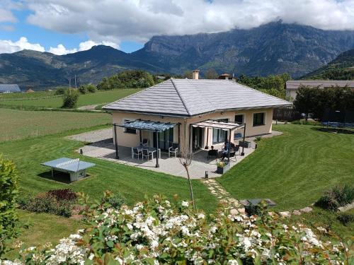 une maison dans un champ avec des montagnes en arrière-plan dans l'établissement Magnifique Villa Sabot de Venus, à Le Lautaret