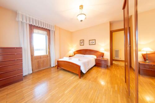 a large bedroom with a bed and a mirror at Historic Village Escape in Burgo de Osma in El Burgo de Osma