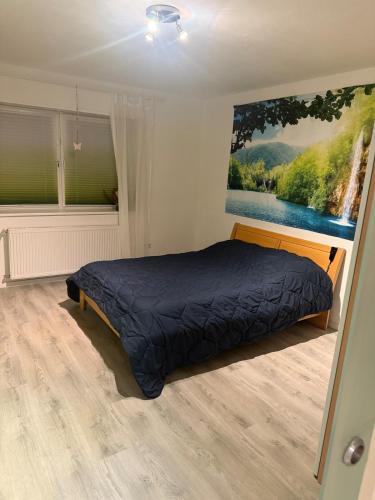 a bedroom with a bed and a painting on the wall at liebevoll eingerichtete Ferienwohnung in idyllischer Lage in Sinsheim
