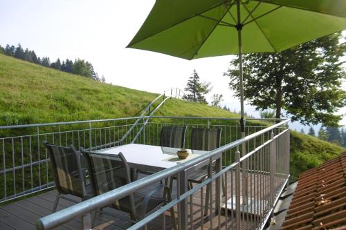 a table and chairs with an umbrella on a balcony at Ferienwohnung Friesenhof Blank In Sulzberg in Sulzberg
