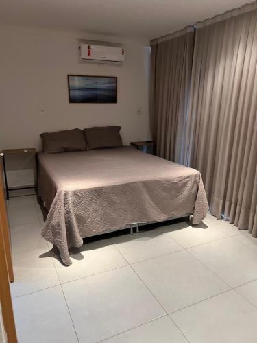 a bedroom with a bed and a tiled floor at Casa em condomínio na praia in Cabedelo