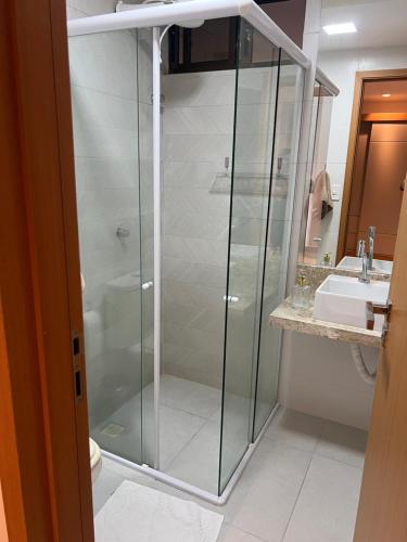 a glass shower in a bathroom with a sink at Casa em condomínio na praia in Cabedelo