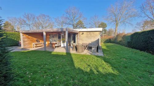 a small house in a field with a green yard at Hello Zeeland - Oosterpark 14 in Oostkapelle