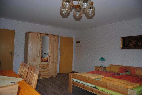 a bedroom with a bed and a cabinet and a table at Ländliche Ferienwohnung In Beliebtem Gästehaus in Windeby