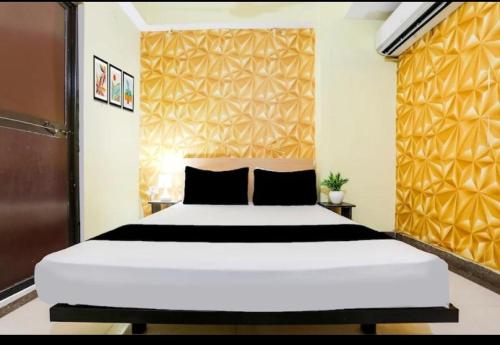 Un dormitorio con una gran cama blanca y una pared amarilla. en Magadh Kutumb Guest House, en Patna
