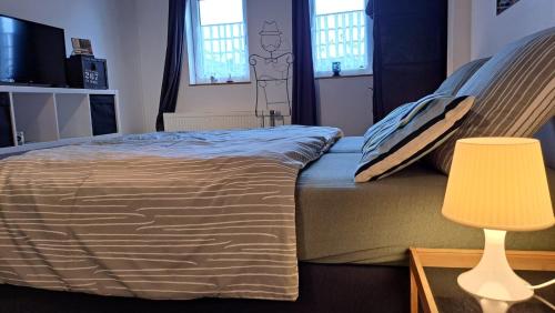 une chambre avec un lit, une lampe et des fenêtres dans l'établissement Chez Martine, à Malmedy