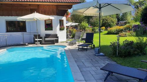 une piscine avec un parasol et des chaises ainsi qu'une terrasse dans l'établissement Ferienwohnung Seitz 1 In Bayerisch Eisenstein, à Bayerisch Eisenstein