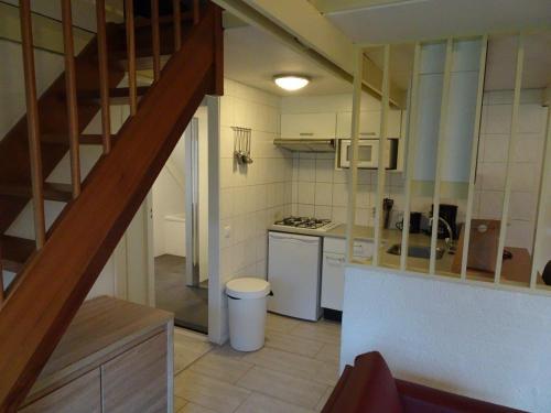 a kitchen with a staircase leading to a kitchen with a stove at Bungalowpark Simpelveld - Alpha 97 in Simpelveld