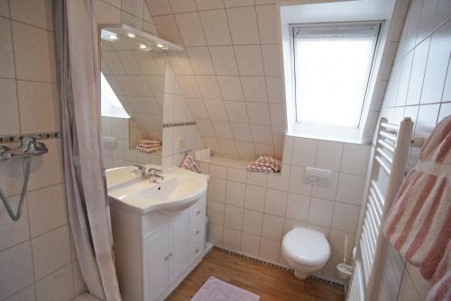 un bagno con lavandino, WC e specchio di Silbermöwe a Fehmarn