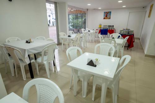 jadalnia z białymi stołami i białymi krzesłami w obiekcie Hotel Serenity Inn w mieście Cartagena de Indias