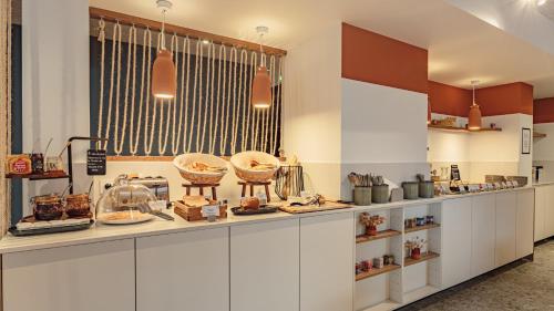 a kitchen with a counter with some food on it at KYRIAD DAX - Saint Paul lès Dax in Saint-Paul-lès-Dax