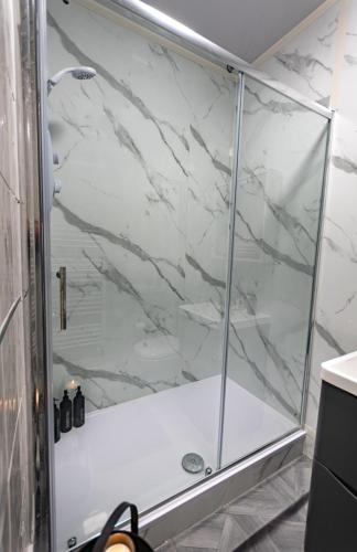 a shower with a glass door in a bathroom at FREE Pool Table Cinema Room TableTennis AirHockey Glasgow City in Glasgow