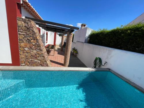 - une piscine sur le côté d'une maison dans l'établissement CASA DAS CAMARINHAS by Stay in Alentejo, à Odemira