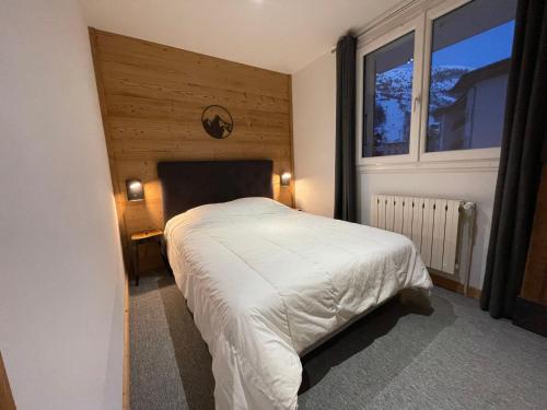 a bedroom with a white bed with a large window at Appartement 2 pièces, 4 pers, balcon, parking, sauna - FR-1-263-87 in Valloire