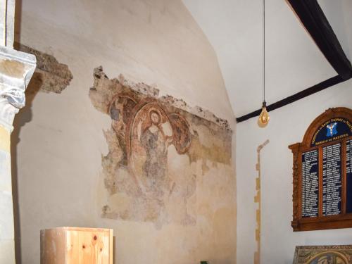 a painting on the wall of a room with a table at The Friars Apartment, Eastbridge Hospital in Canterbury