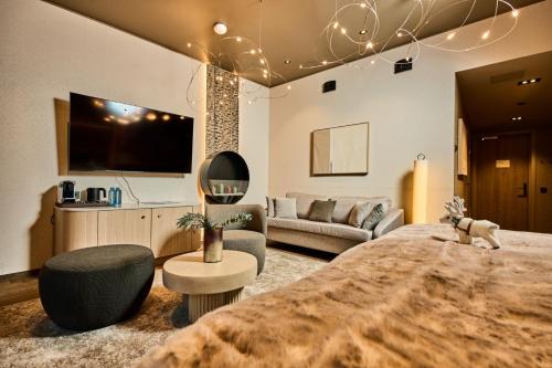 ein Schlafzimmer mit großem Bett und ein Wohnzimmer in der Unterkunft Balder Luxury Lodge & Glass Igloos in Levi