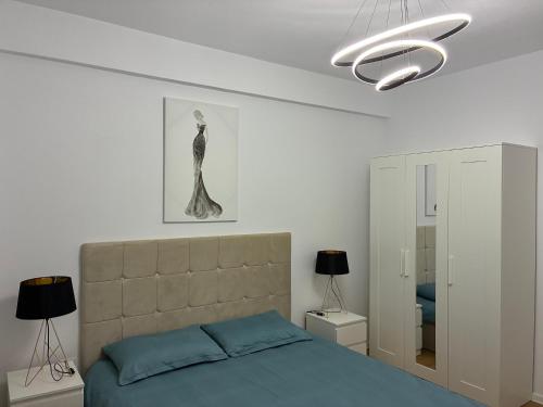 a bedroom with a blue bed and a chandelier at Cristina Home in Alba Iulia