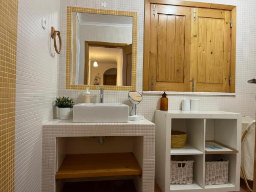 une salle de bain avec un lavabo et un miroir dans l'établissement CASA DAS CAMARINHAS by Stay in Alentejo, à Odemira