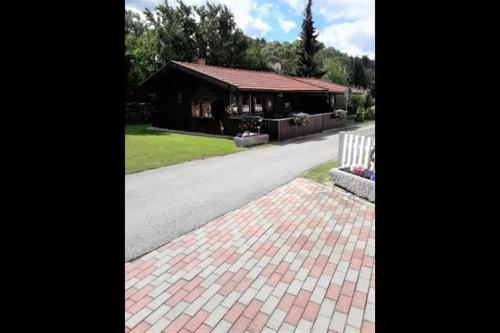 ein Haus in einer Straße mit einem gemauerten Gehweg und einer Straße in der Unterkunft Ferienhaus für 4 Personen ca 45 m in Eppenschlag, Bayern Bayerischer Wald in Eppenschlag