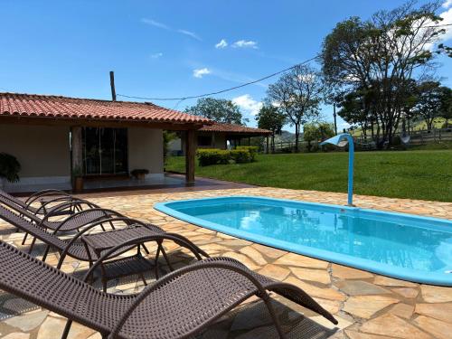 un patio avec des chaises et une piscine dans l'établissement Pousada Império de Minas, à Capitólio