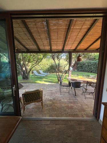 eine offene Tür zu einer Terrasse mit Tisch und Stühlen in der Unterkunft Villa a Capalbio in Carige Bassa