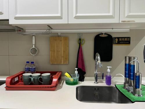 PARIS iCity ITQAN Homes 8pax,Netflix,Coway,Parking في شاه عالم: طاولة مطبخ مع حوض وصينية مع أكواب