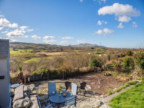 a patio with a table and chairs and a view at Hyfrydle Cottage in Pen-y-groes