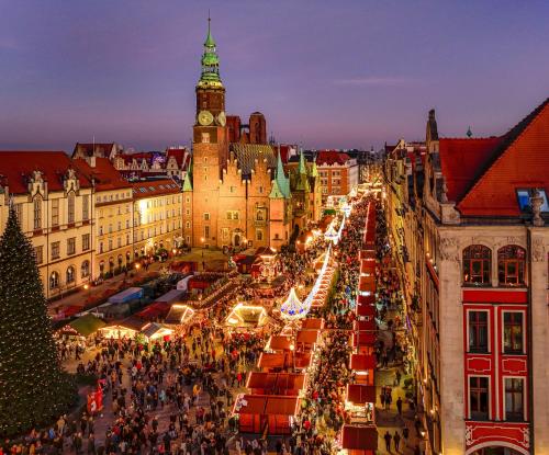 a christmas market in a city with a clock tower at Ibis Styles Wroclaw Centrum in Wrocław