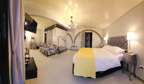 a bedroom with a bed and a tv and a couch at Sunbloom Beachfront Hotel and Restaurant Zambales in Sinabacan