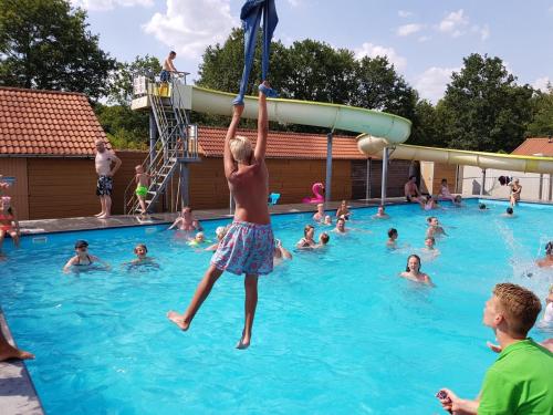a young boy is playing in a swimming pool at Chalet de Hunestee in Schoonloo