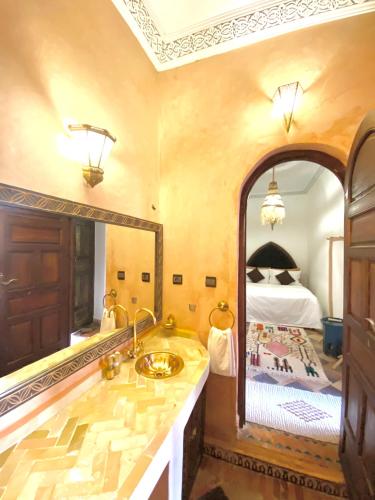 a bathroom with a sink and a large mirror at Riad Musa in Marrakesh