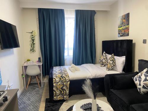 a bedroom with a bed with blue curtains and a couch at Winnie's home in Athi River