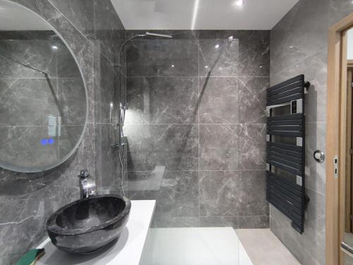 La salle de bains est pourvue d'un lavabo noir et d'une douche. dans l'établissement l'Ecrin Vert Disney Land Maison 2chambres, à Chalifert