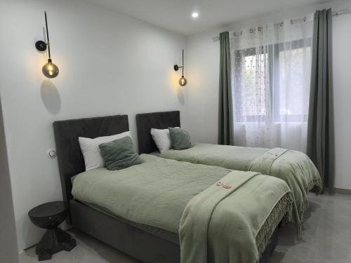 une chambre avec deux lits et une fenêtre dans l'établissement l'Ecrin Vert Disney Land Maison 2chambres, à Chalifert