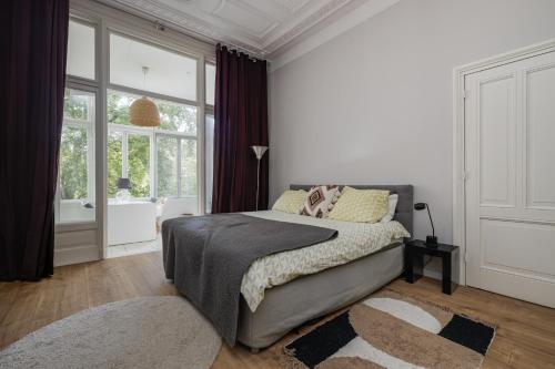 a bedroom with a bed and a tub and a window at Westersingel in Rotterdam