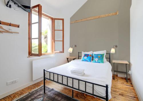a bedroom with a white bed with blue pillows at Maison semi-troglodyte entre Loire et châteaux in Rochecorbon