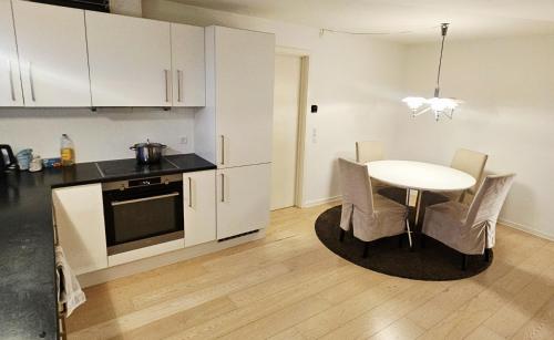 a kitchen with a table and a kitchen with white cabinets at Easy stay in Glostrup