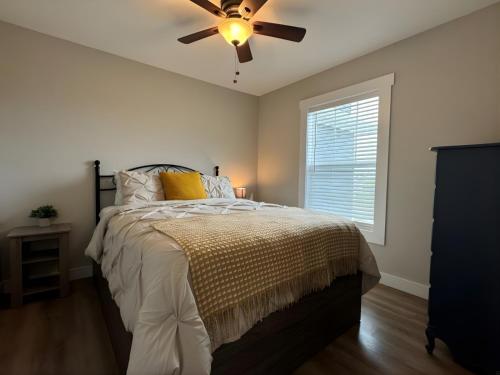 une chambre avec un lit avec un ventilateur de plafond dans l'établissement The Retreat - Sherbrooke Cottages, à Summerside