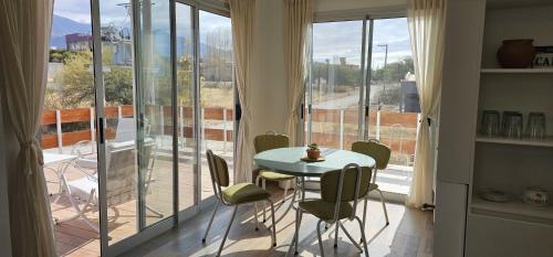 una stanza con tavolo, sedie e balcone di Vistas del Yásta casa boutique privada a Cafayate